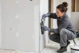 Stuccatura dei giunti su cartongesso: applicazione manuale per uniformare la superficie e prepararla alla finitura.